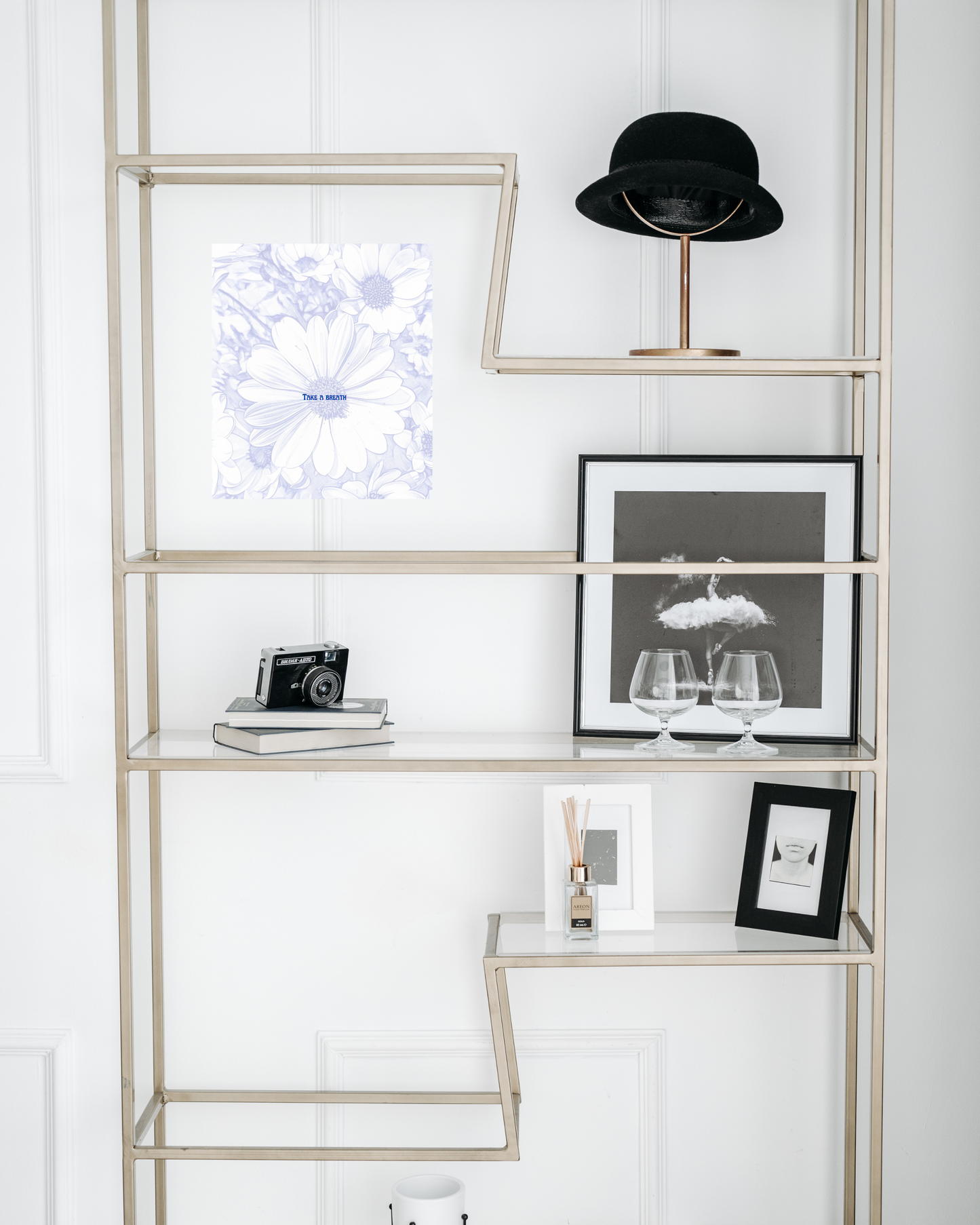 classic glass bookshelf with black and white decor items and original floral art design with 'take a breath' message