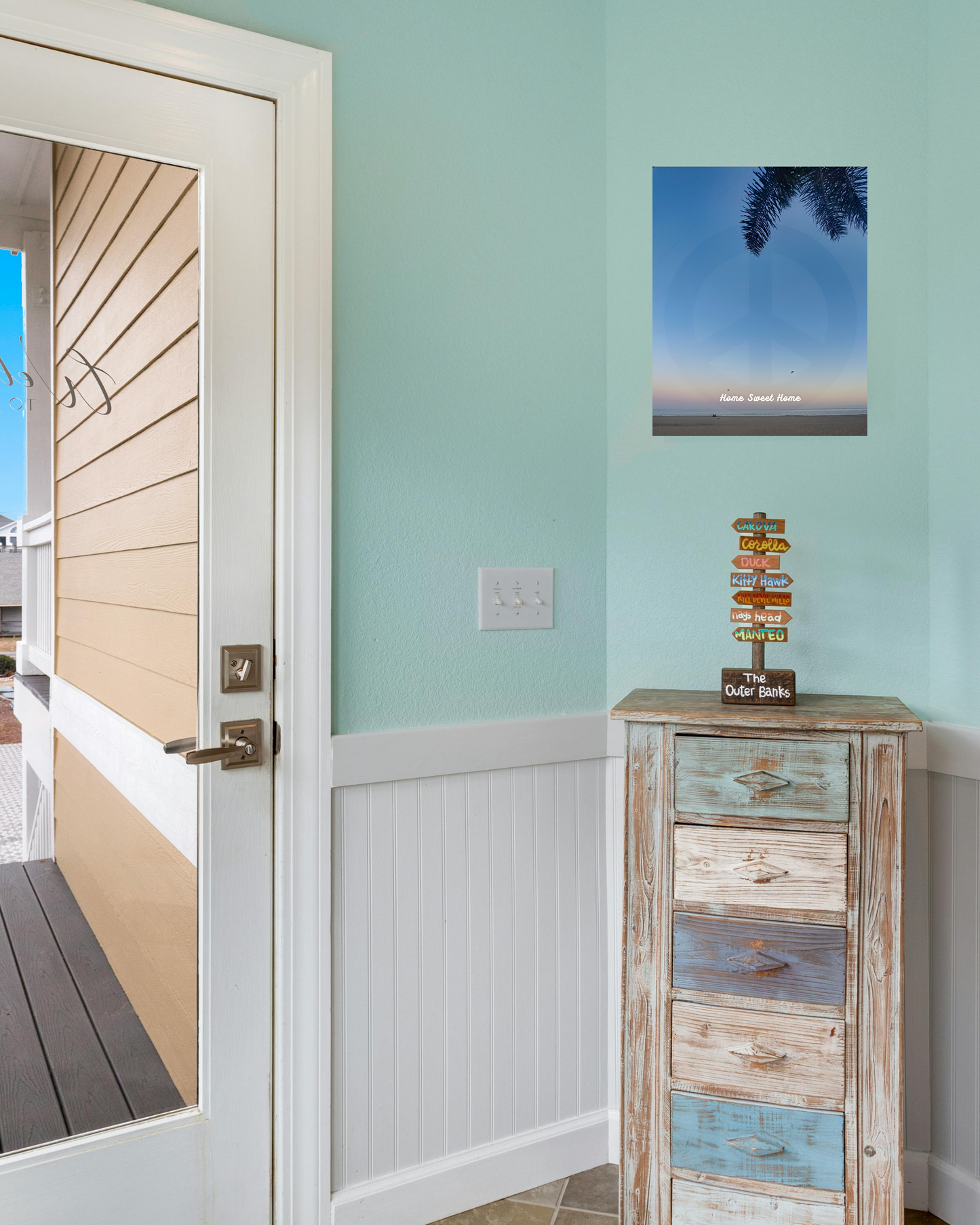 Wooden side table in a home with beach decor and canvas beach sunset art with palm tree and relaxing peace sign motif