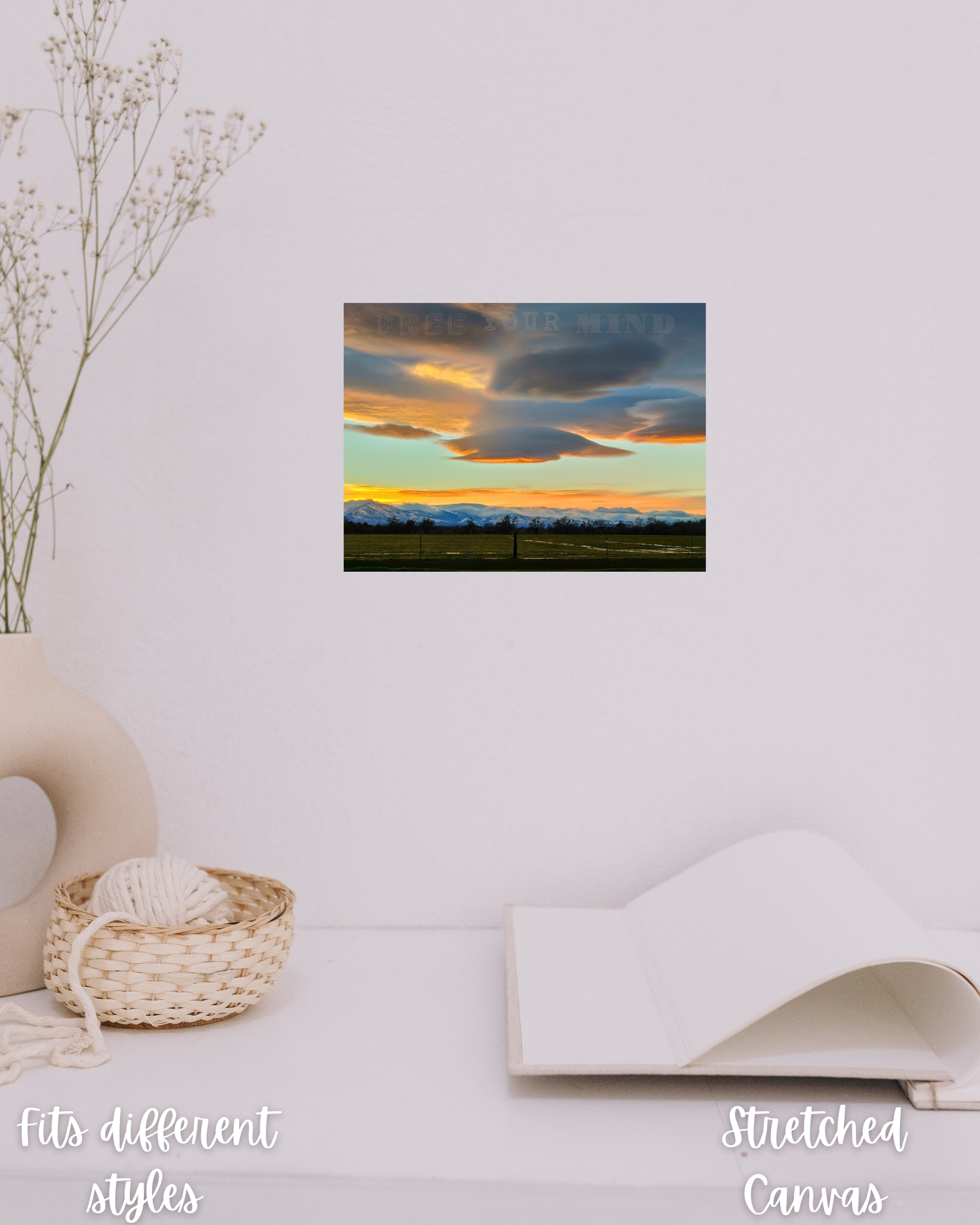 simple warm Scandinavian hygge decor with bright sunset wall print with snowcapped mountains, green fields, and floating clouds