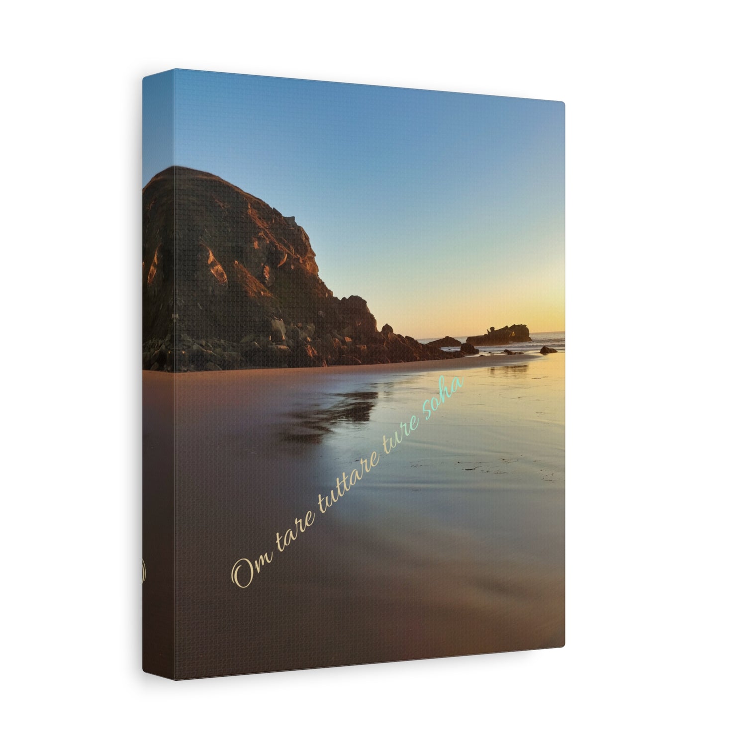 Canvas print of a golden beach scene with large rocks and unblemished sand. features compassion mantra written across the art 