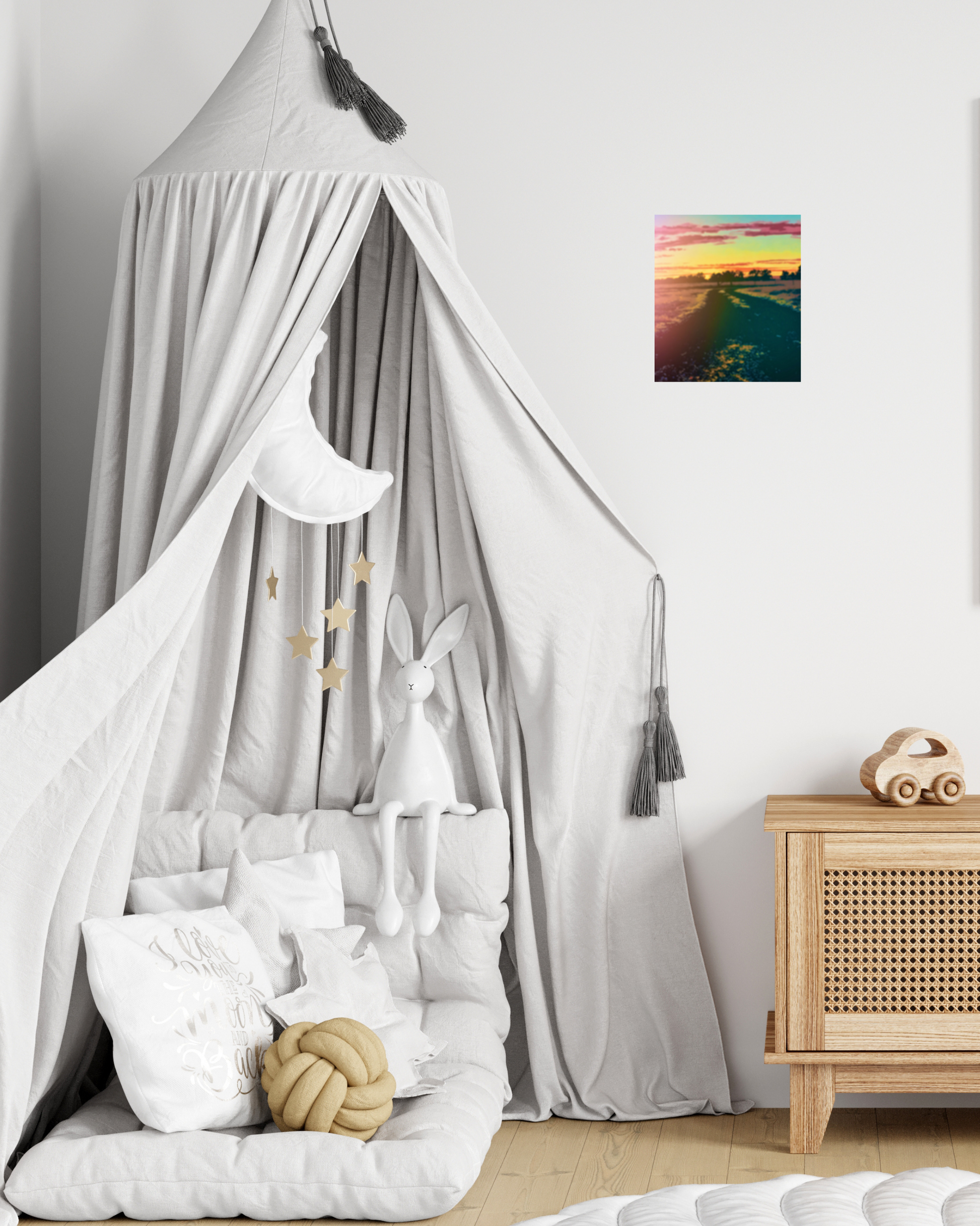 young child's bedroom with a canopy bed, toys, and a wall art of a country sunset with warm calming colors