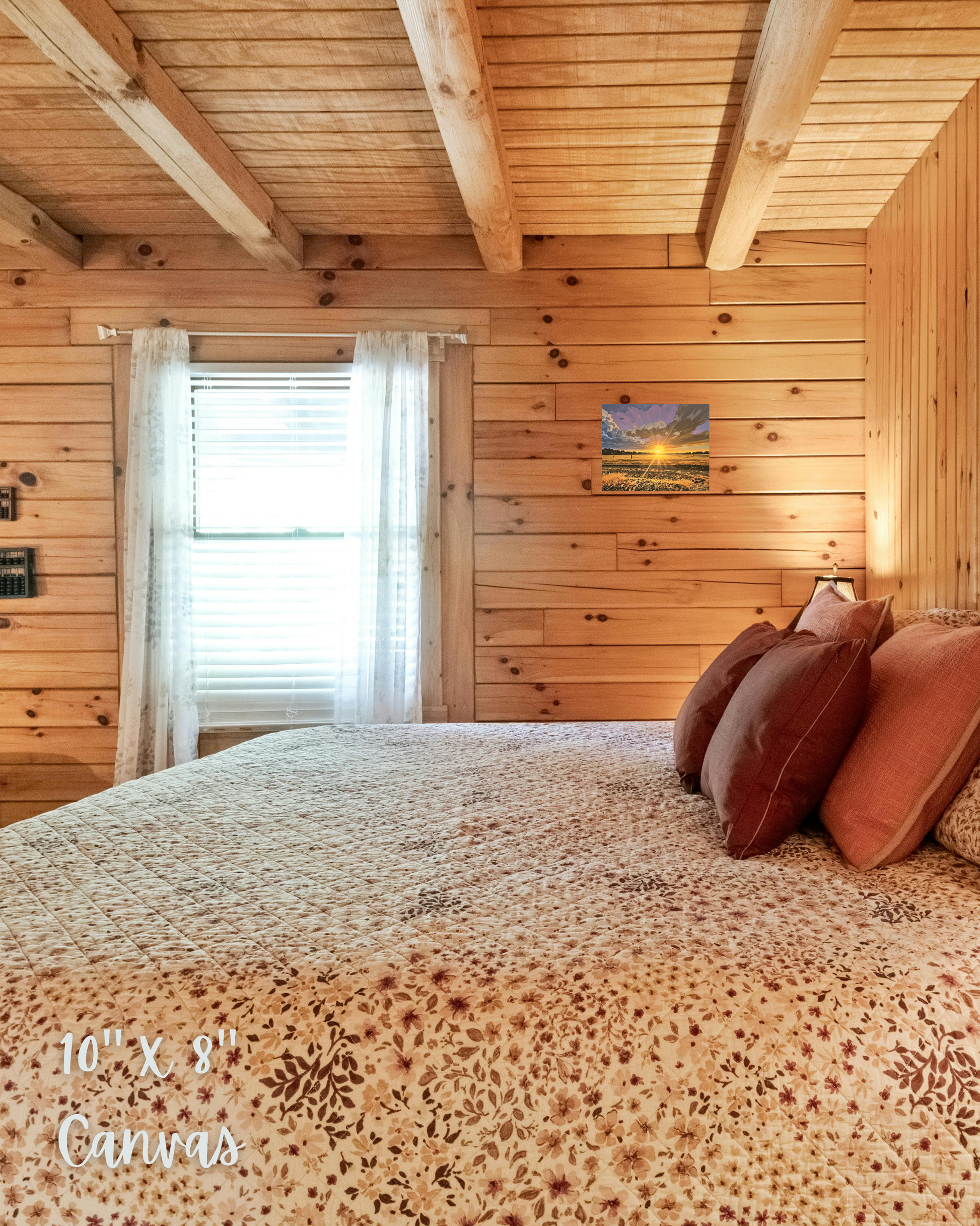 cabin bedroom with warm lighting and decor. features wall art with showing rural country sunset during golden hour with rangeland and purples skies