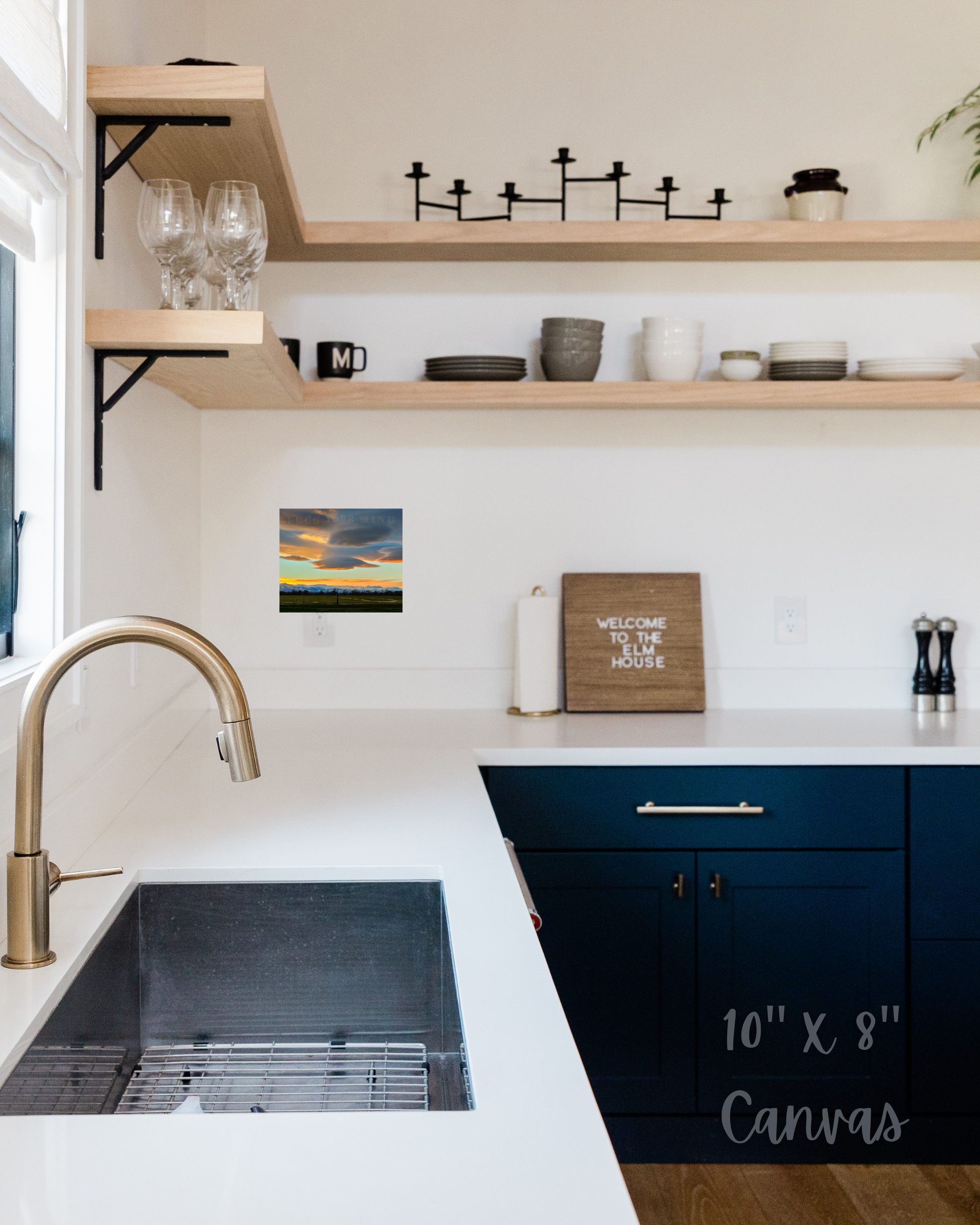 Modern kitchen with open shelves, sink, and decorative elements including engaging wall art with nature scene and snow sprinkled atop the hills