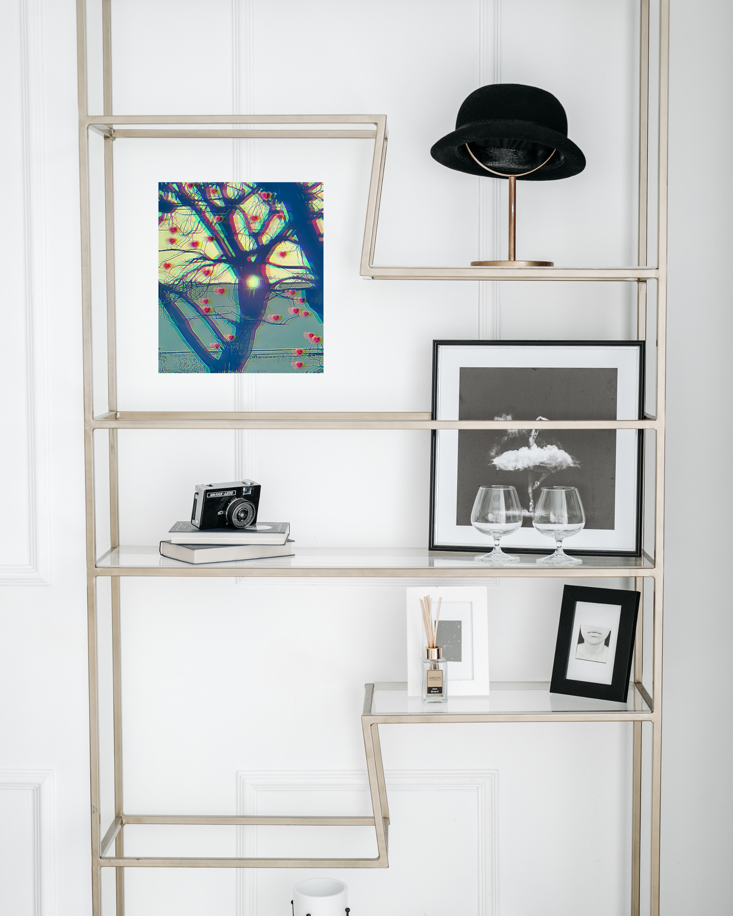 classy art deco book shelf with artsy decor and wall art depicting sunset through a tree hole on a barren tree appearing to grow hearts